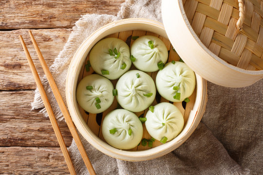 Traditional chinese baozi steam buns in a bamboo steamer basket close-up. Horizontal top view