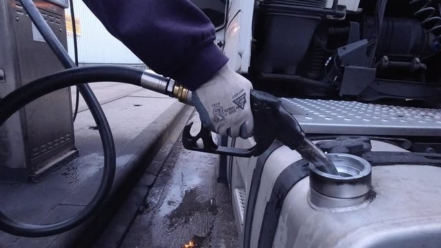 Close up shot of a diesel pump being put into a HGV fuel tank for refilling.
