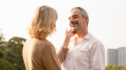 Portrait of senior caucasian couple holding each other feeling loved and happy in the afternoon sun, elderly couple anniversary, elderly togetherness, happy retirement,romantic couple, love expression