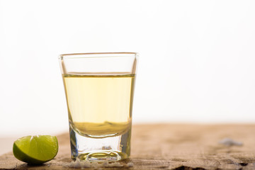 Vodka in a shot glass on a brown wooden background prepared for a party