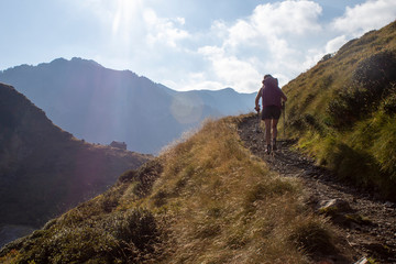 Fototapeta premium hiker walking on a small mountain trail