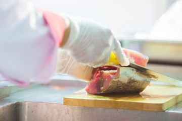 Chef cutting fresh tuna fish in the kitchen