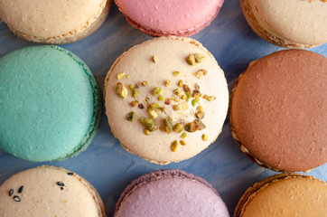  Multi-colored macarons on a blue texture background. 