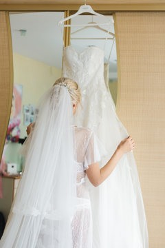 The details of the wedding day. The bride adjusts her wedding dress