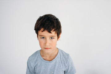 Frustrated Moody tween boy looking at camera on white background