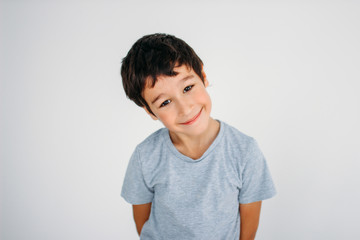 Cute smiling tween boy looking at camera on white background