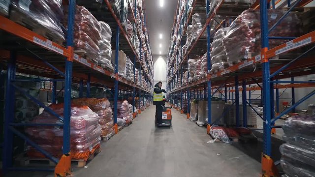 loader moves on a forklift in a warehouse