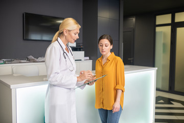 Blond doctor in white robe looking serious