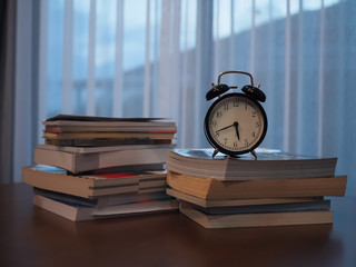 old books and alarm clock on desk