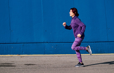 woman running with winter clothes for fitness - sports concept