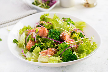 Salad of baked fish salmon, broccoli, lettuce, red onion and dressing. Fish menu. Seafood - salmon.