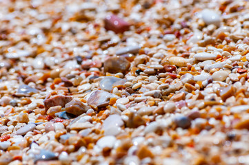 Coastal pebbles washed by Adriatic Sea water waves on Baia delle Zagare beach in Gargano National Park, Italy