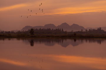 Beautiful sunrise with red sky and reflection in the lake
