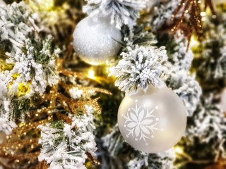 Christmas tree covered in snow decorated with beautiful ornaments and lighting,celebrate  seasonal.garland background and xmas wallpaper.golden christmas tree decoration