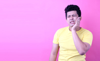 Young  Asia man with a toothache on pink background in studio With copy space.