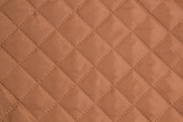 Quilted fabric. The texture of the blanket.	Beige textile