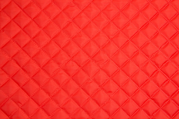 Fototapeta na wymiar Quilted fabric. The texture of the blanket. Red textile