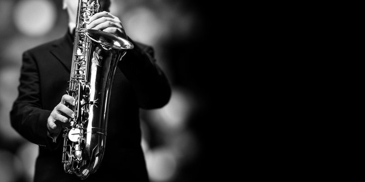 The saxophone player at the jazzclub - open place for text on black background