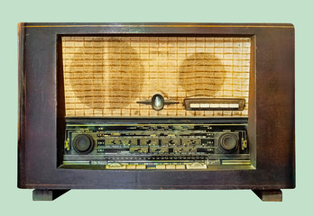 Old tube tabletop radio in wooden case, on isolated pale green background with clipping path.