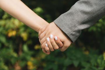 Groom and brides hands with rings, closeup view