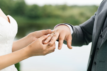 Bride and groom exchange rings close up