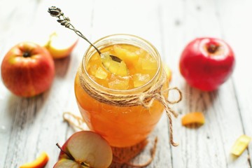Homemade apple jam with orange zest. Jam in a glass jar. Jam on a wooden background, top view. Place for text