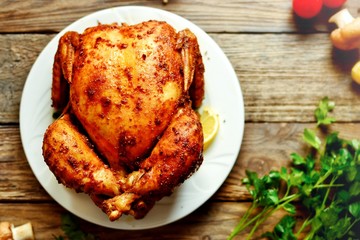 Whole baked chicken curry with golden crisp. Baked chicken on a wooden background.
