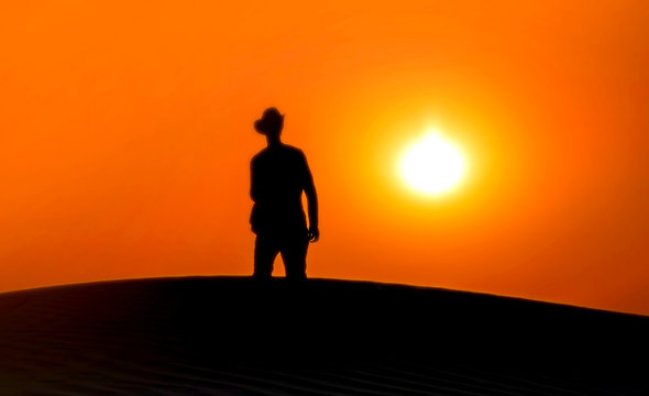 Silhouette of man sunset in desert