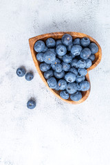 healthy eating antioxidant blueberries in a wooden bowl heart shaped top view