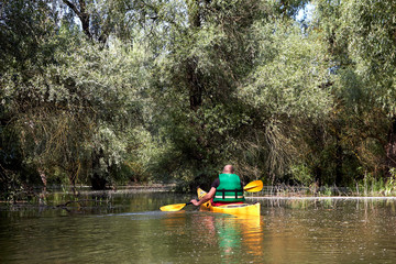 Tourist on yellow kayak kayaking on Danube river at summer