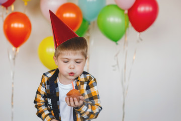 Fototapeta na wymiar Boy blows out a birthday candle.