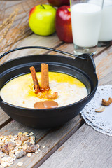 Traditional breakfast. Milk oatmeal with chocolate and granola. on a wooden table.