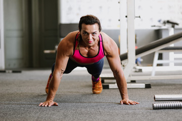 Fototapeta na wymiar bodybuilder push ups on the gym floor