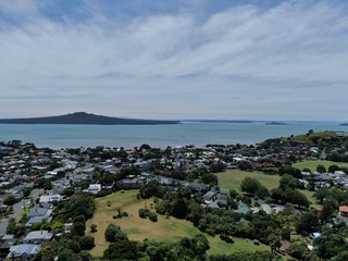 Devonport, Auckland / New Zealand - December 11, 2019: The Victorian Style Seaside Village of Devonport, with the skyline of Auckland’s landmarks and CBD in the background