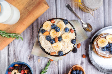 rustic delicious Breakfast oatmeal with nuts and bananas and pancakes