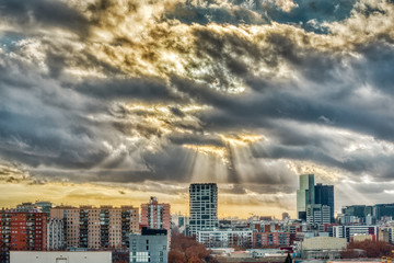 Fototapeta premium paisaje urbano con el cielo encapotado de nubes y rayos de sol
