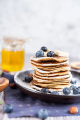 delicious Breakfast pancakes on a plate with blueberries and honey