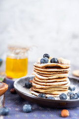 delicious Breakfast pancakes on a plate with blueberries and honey