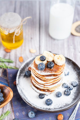 pancakes on a plate with blueberries and milk