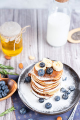 pancakes on a plate with blueberries and milk