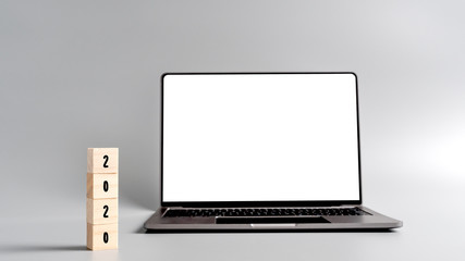 2020 letter on wood cube with blank space background on computer laptop mockup, New Year plan resolution
