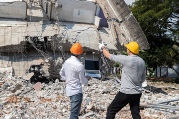 Demolition control supervisor and contractor discussing on demolish building.