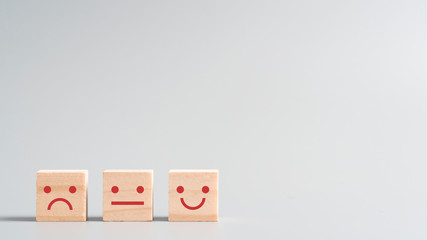 close up emoji face icon on wood cube, customer service, feedback, satisfaction concept