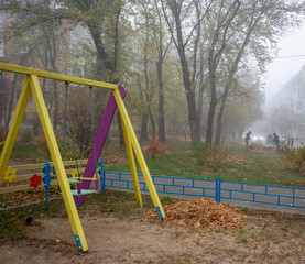 Morning fog and a swing in a city park