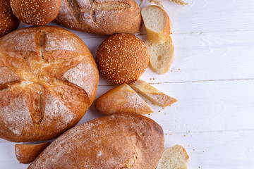 Freshly Baked Homemade Bread, close-up, isolated on a white background. Assortment of baked bread on wooden table background