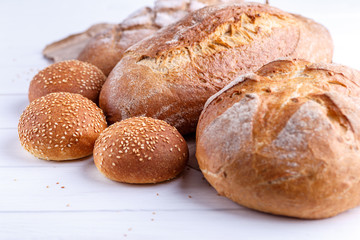 Freshly Baked Homemade Bread, close-up, isolated on a white background. Assortment of baked bread on wooden table background