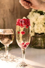 Sparkle wine in glass with red currant berries