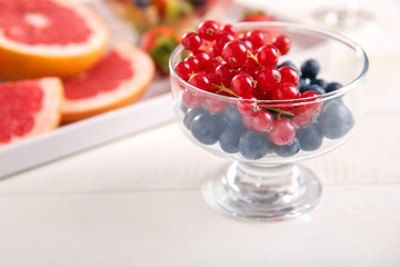 Glass bowl with tasty berries on table