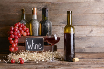 Naklejka premium Box with bottles of different wine on wooden table