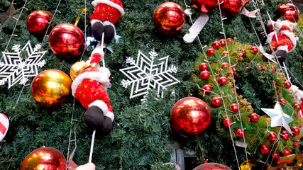 Christmas decoration. Hanging red balls, santa claus and Snowflake on pine branches and tree background.